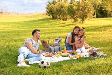 Happy family having picnic in park on sunny summer day