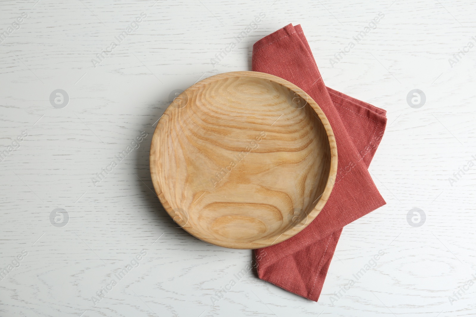 Photo of Empty plate and napkin on white wooden table, flat lay