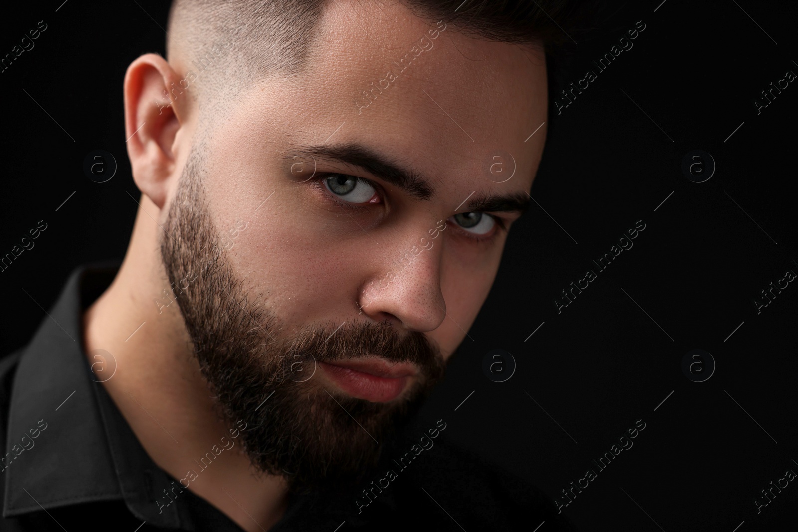 Photo of Evil eye. Man with scary eyes on black background, space for text