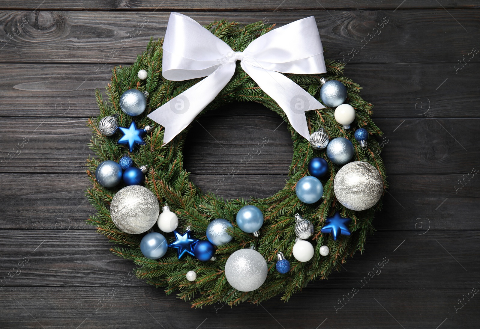 Photo of Beautiful Christmas wreath on black wooden background, top view