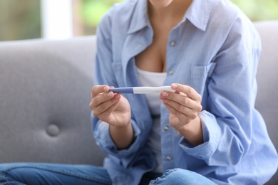 Young woman with pregnancy test at home. Gynecology