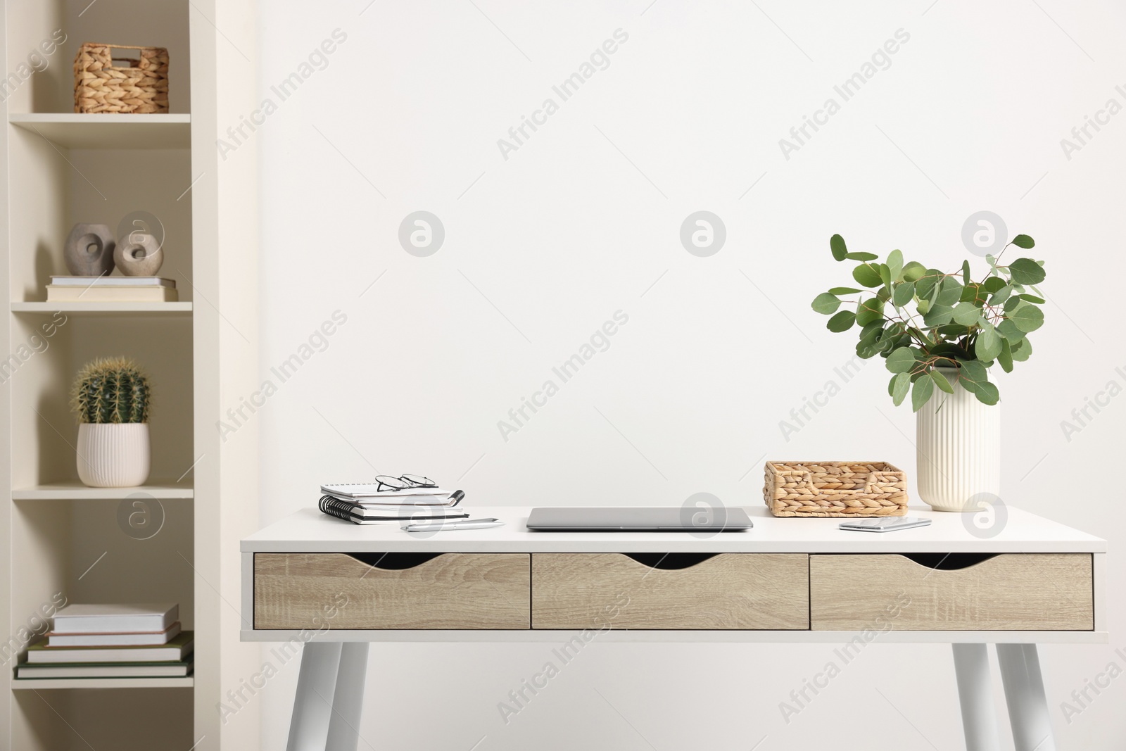 Photo of Home office. Laptop, glasses, stationery and plant on white desk indoors. Space for text