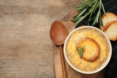 Tasty homemade french onion soup served on wooden table, flat lay. Space for text