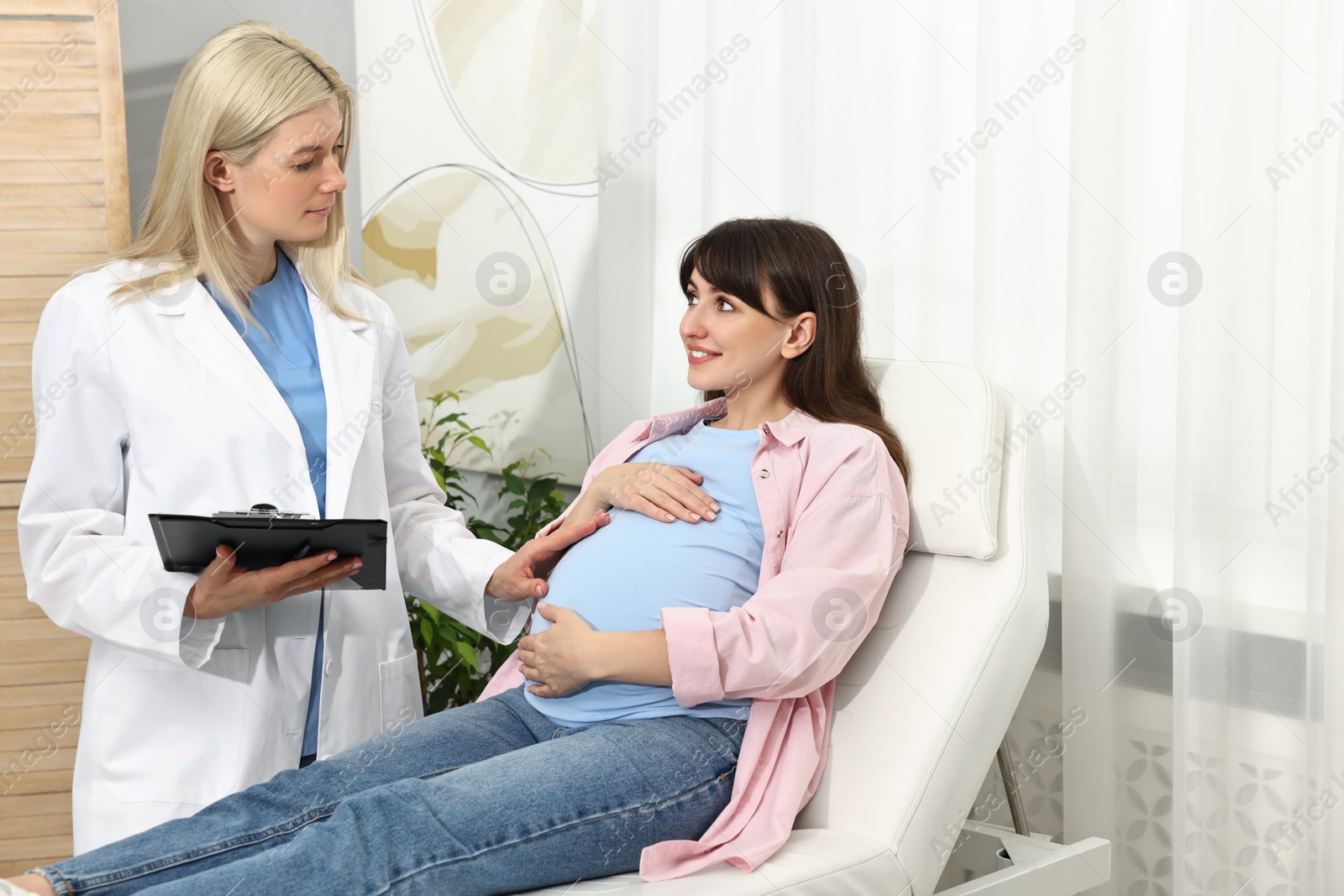 Photo of Happy pregnant woman having doctor appointment in hospital