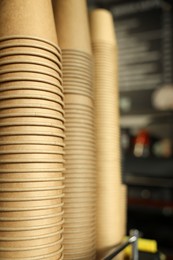 Stacks of takeaway paper coffee cups in cafe, closeup