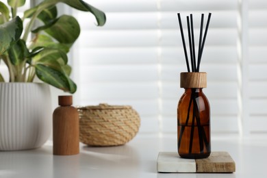 Air reed freshener on white table near window