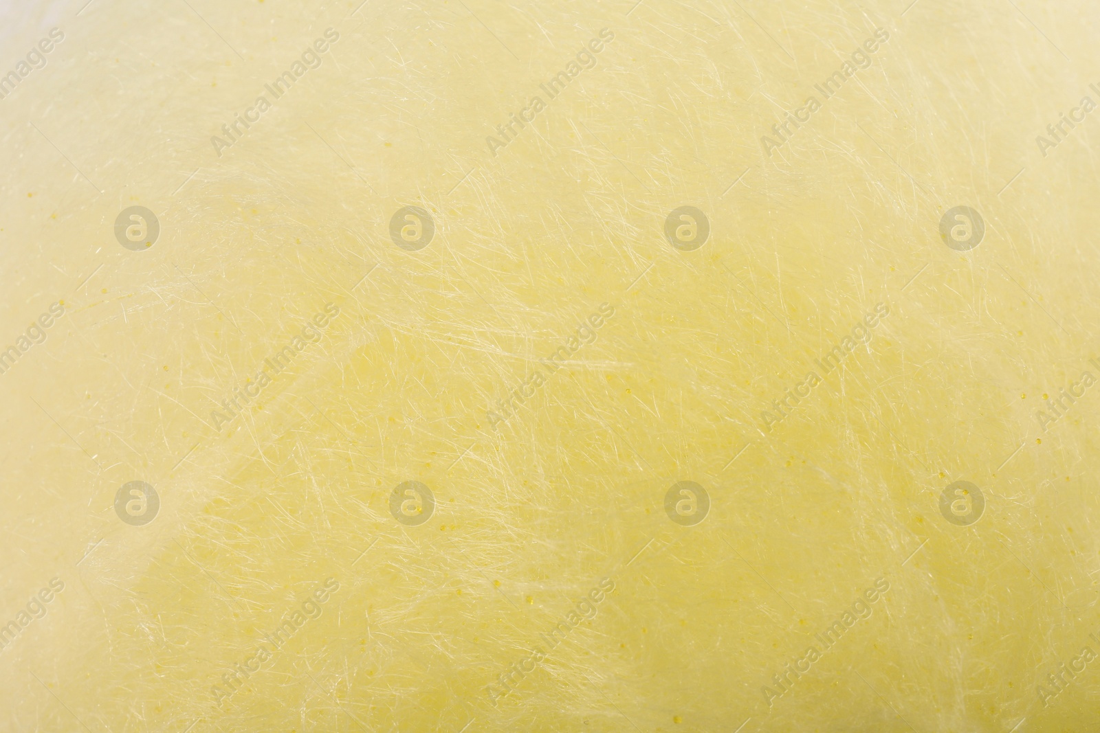 Photo of Texture of sweet yellow cotton candy as background, closeup