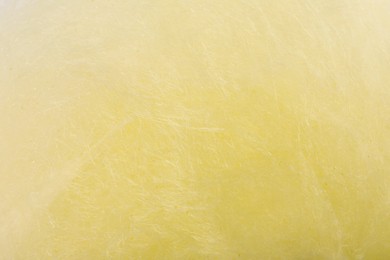 Texture of sweet yellow cotton candy as background, closeup