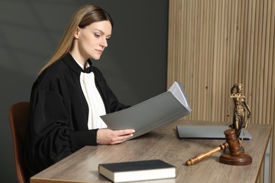Judge with folder working at table in courtroom