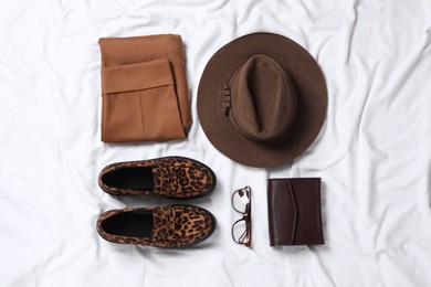 Photo of Flat lay composition with stylish hat on white fabric
