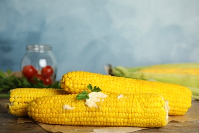 Fresh corn cobs with butter on wooden table