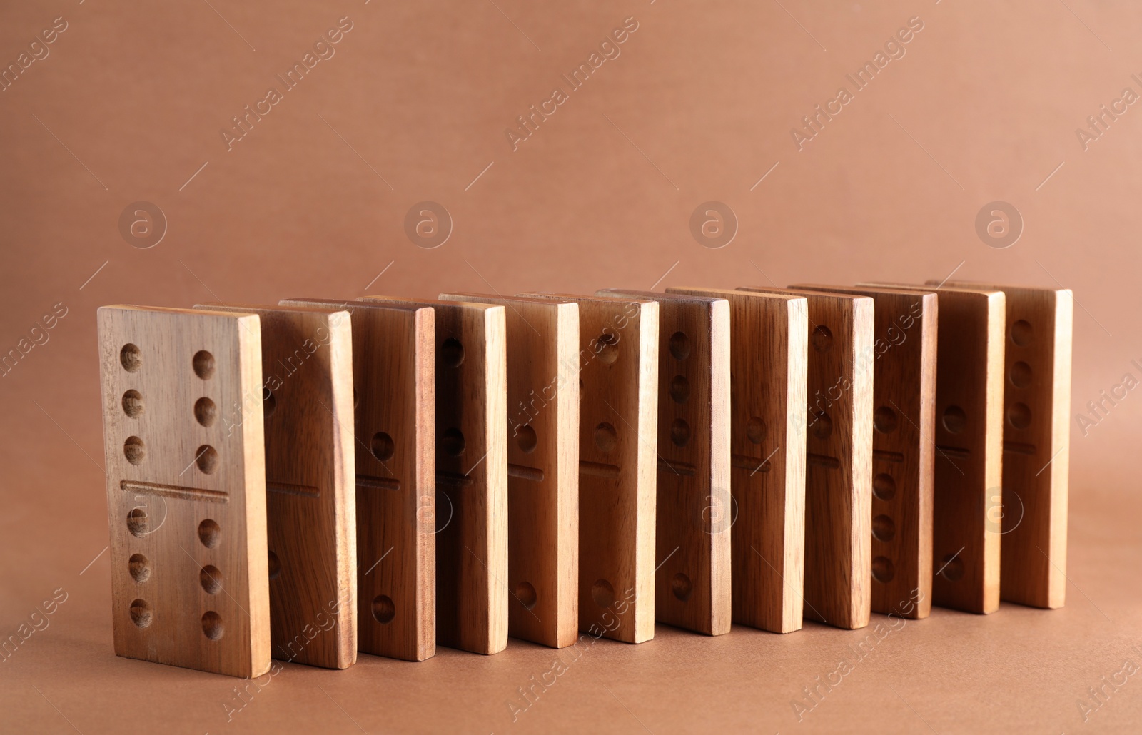 Photo of Wooden domino tiles with pips on brown background