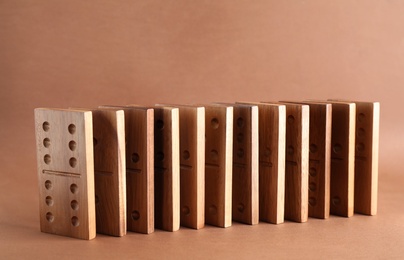 Photo of Wooden domino tiles with pips on brown background