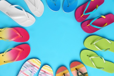 Photo of Flat lay composition with different flip flops on blue background, space for text. Summer beach accessories