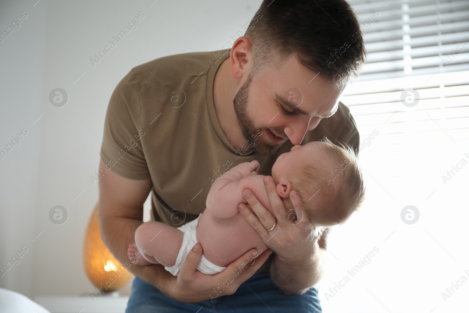 Photo of Father with his newborn son at home