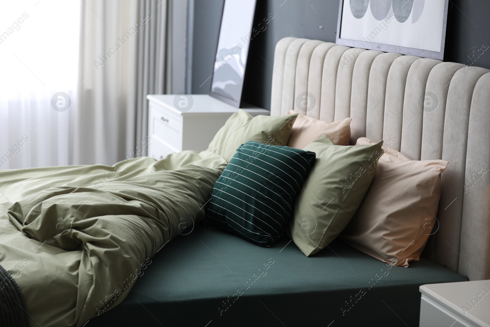 Photo of Comfortable bed with new pistachio linens in modern room interior