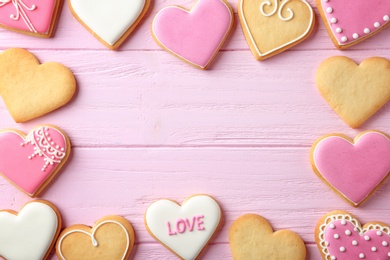 Flat lay composition with heart shaped cookies and space for text on wooden background. Valentine's day treat