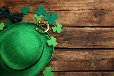 Photo of Flat lay composition with leprechaun hat on wooden table, space for text. St Patrick's Day celebration