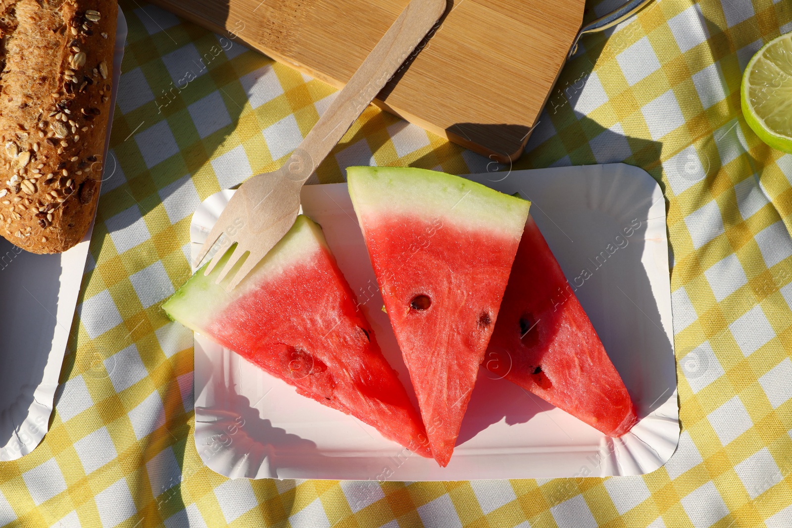 Photo of Delicious watermelon and bread on picnic blanket, flat lay