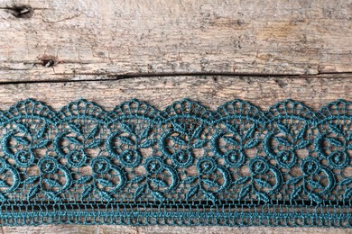 Photo of Beautiful lace on wooden table, top view. Space for text