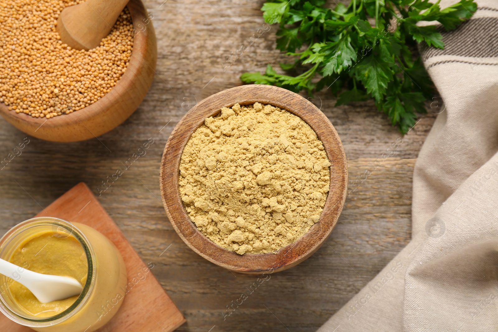 Photo of Flat lay composition with mustard powder, seeds and parsley on wooden table