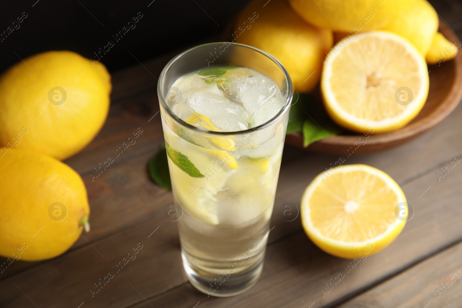 Photo of Cool freshly made lemonade and fruits on wooden table, closeup