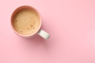 Photo of Aromatic coffee in cup on pink background, top view. Space for text