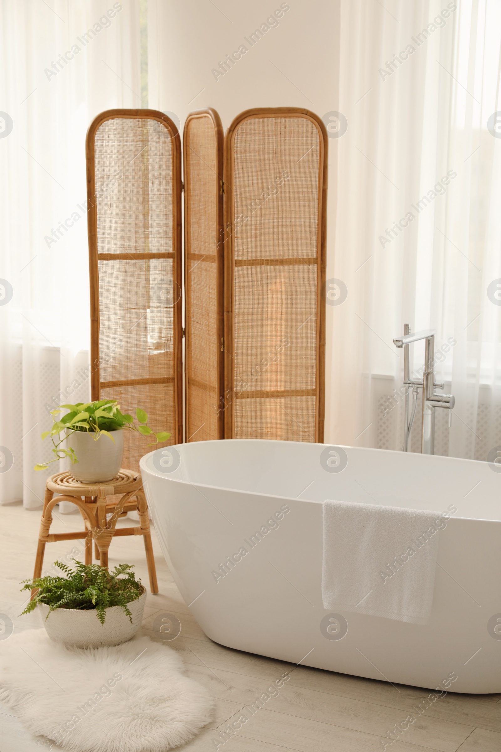 Photo of White tub near window in light room. Interior design