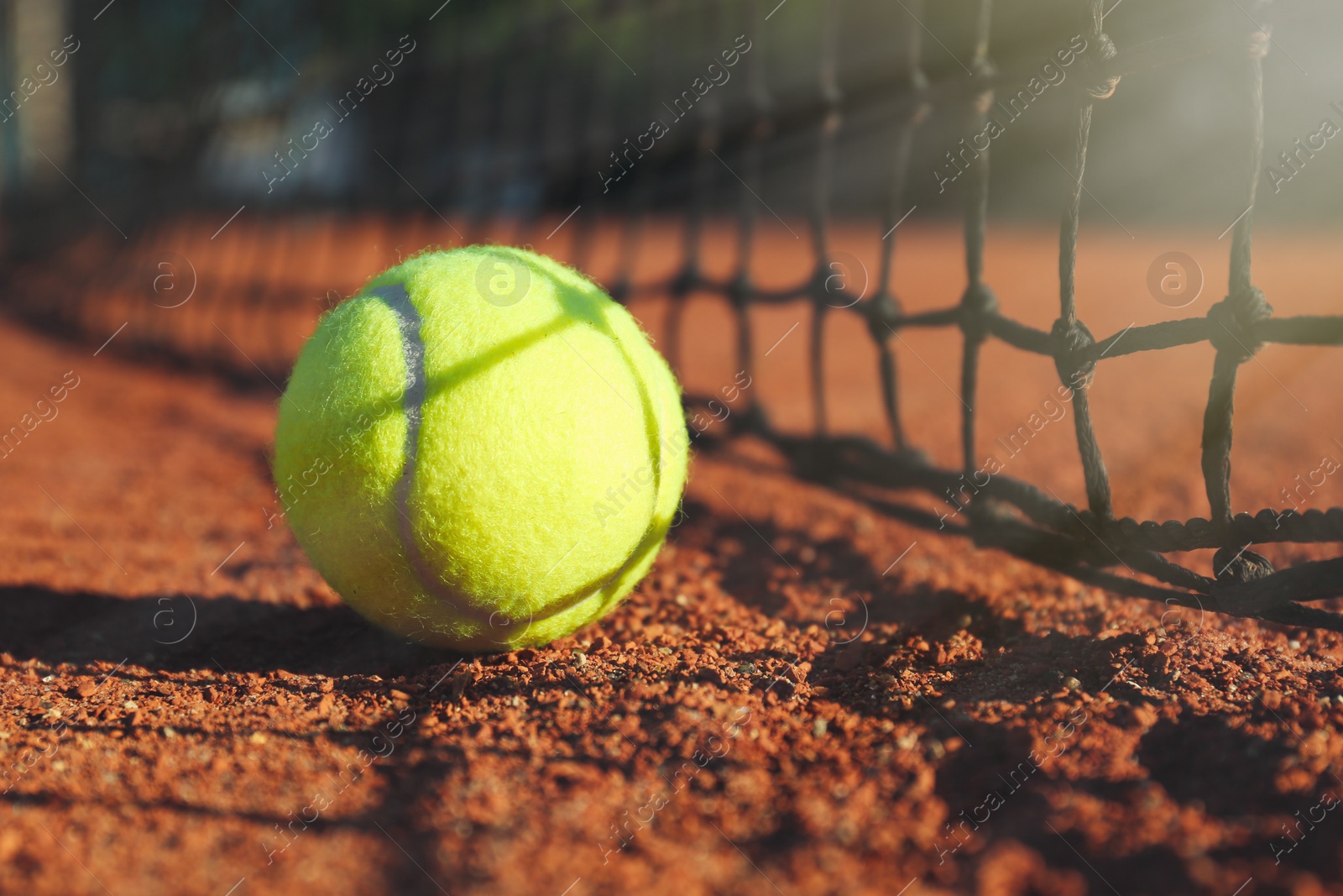 Photo of Tennis ball near net on clay court