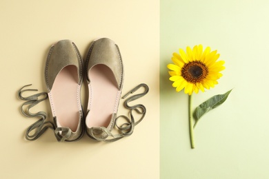 Photo of Pair of trendy women's shoes and sunflower on color background