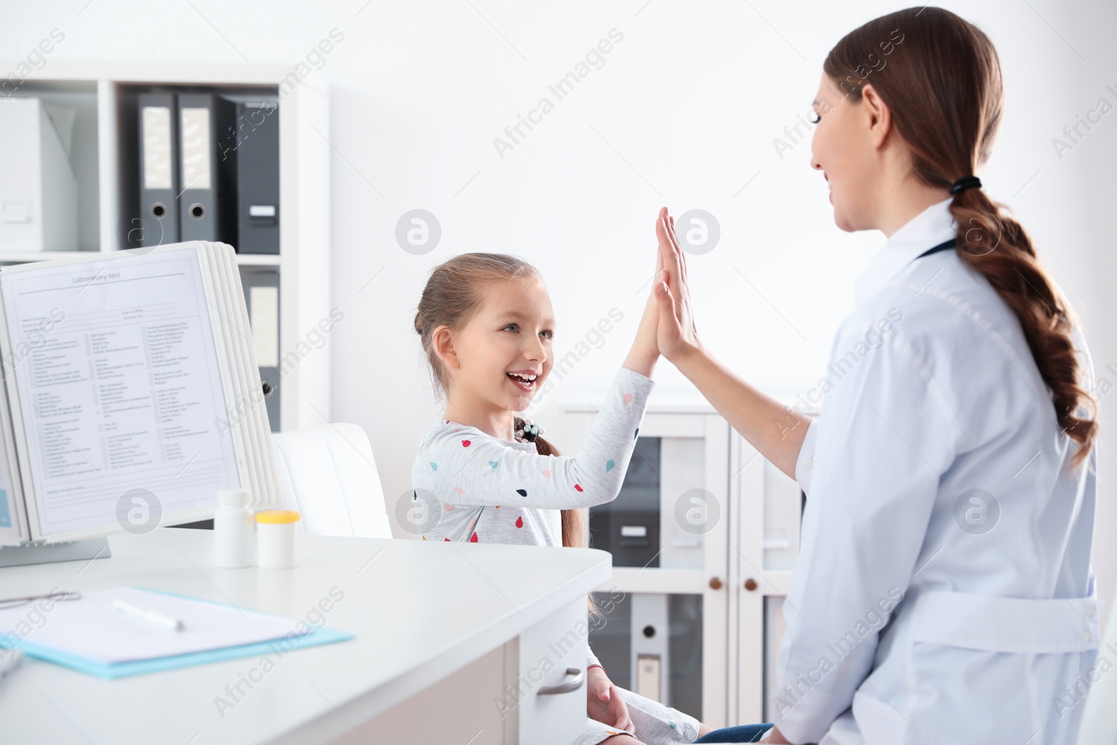 Photo of Children's doctor working with little patient in clinic