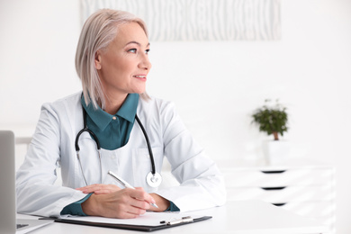 Photo of Mature female doctor in white coat at workplace