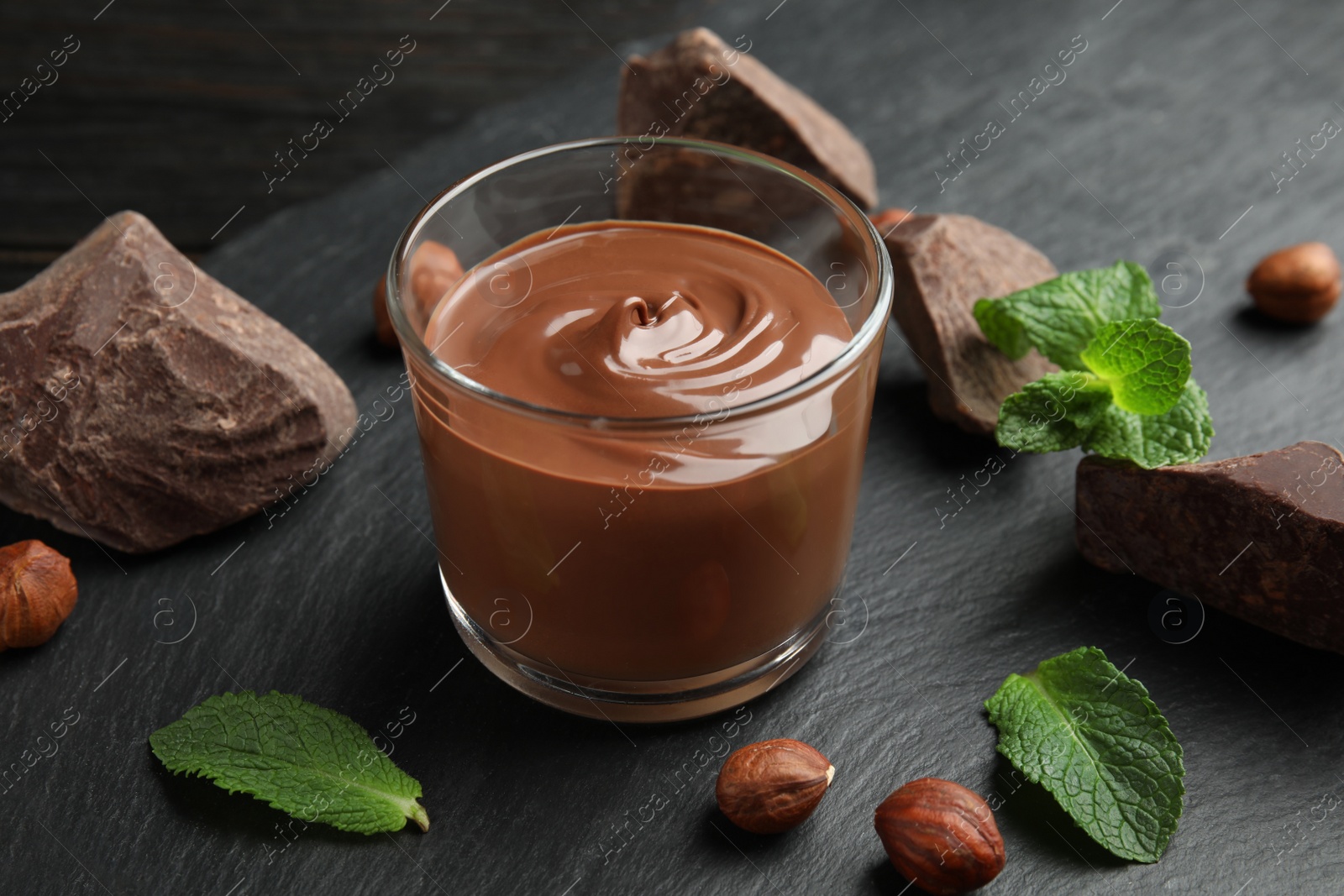 Photo of Composition with sweet chocolate mousse in glass on table