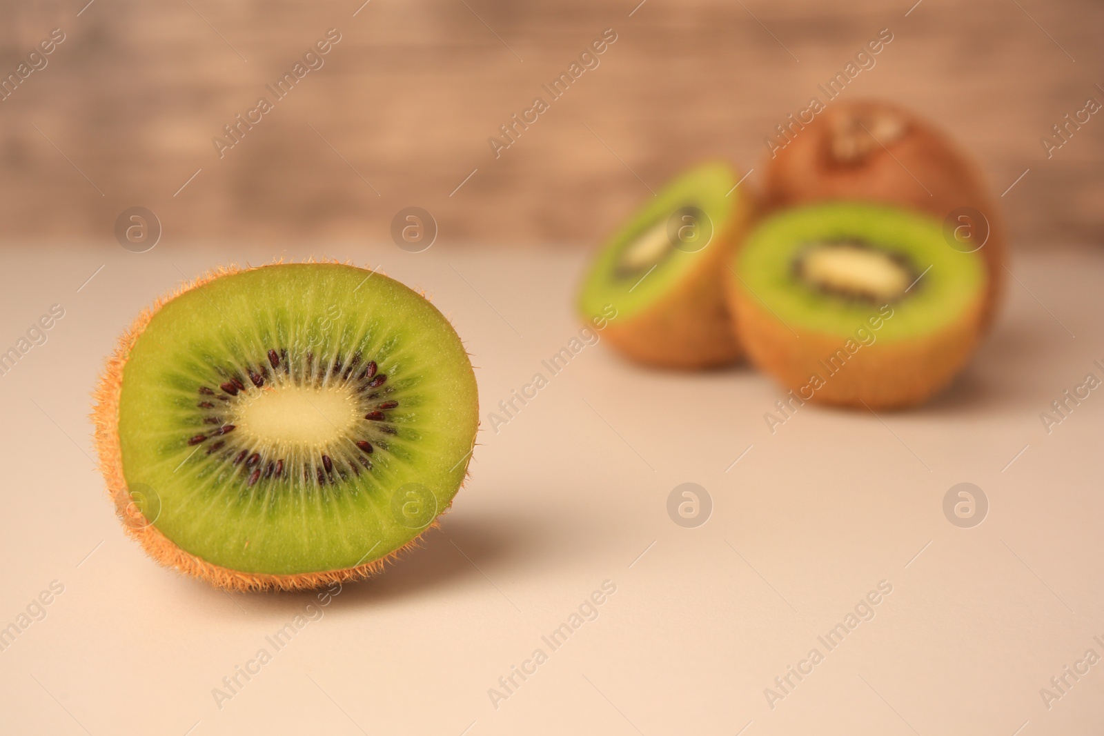 Photo of Delicious fresh ripe kiwi on beige background, space for text