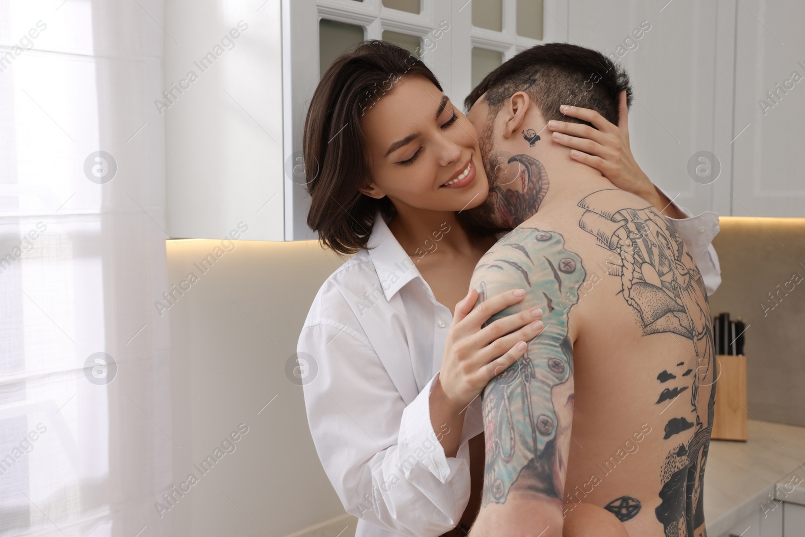 Photo of Passionate young couple having sex in kitchen