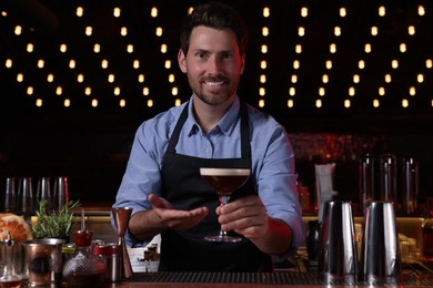 Bartender with Espresso Martini in bar. Alcohol cocktail