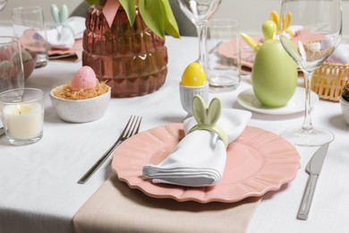 Festive table setting with napkin ring in shape of bunny ears. Easter celebration