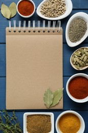 Blank recipe book and different spices on blue wooden table, flat lay. Space for text