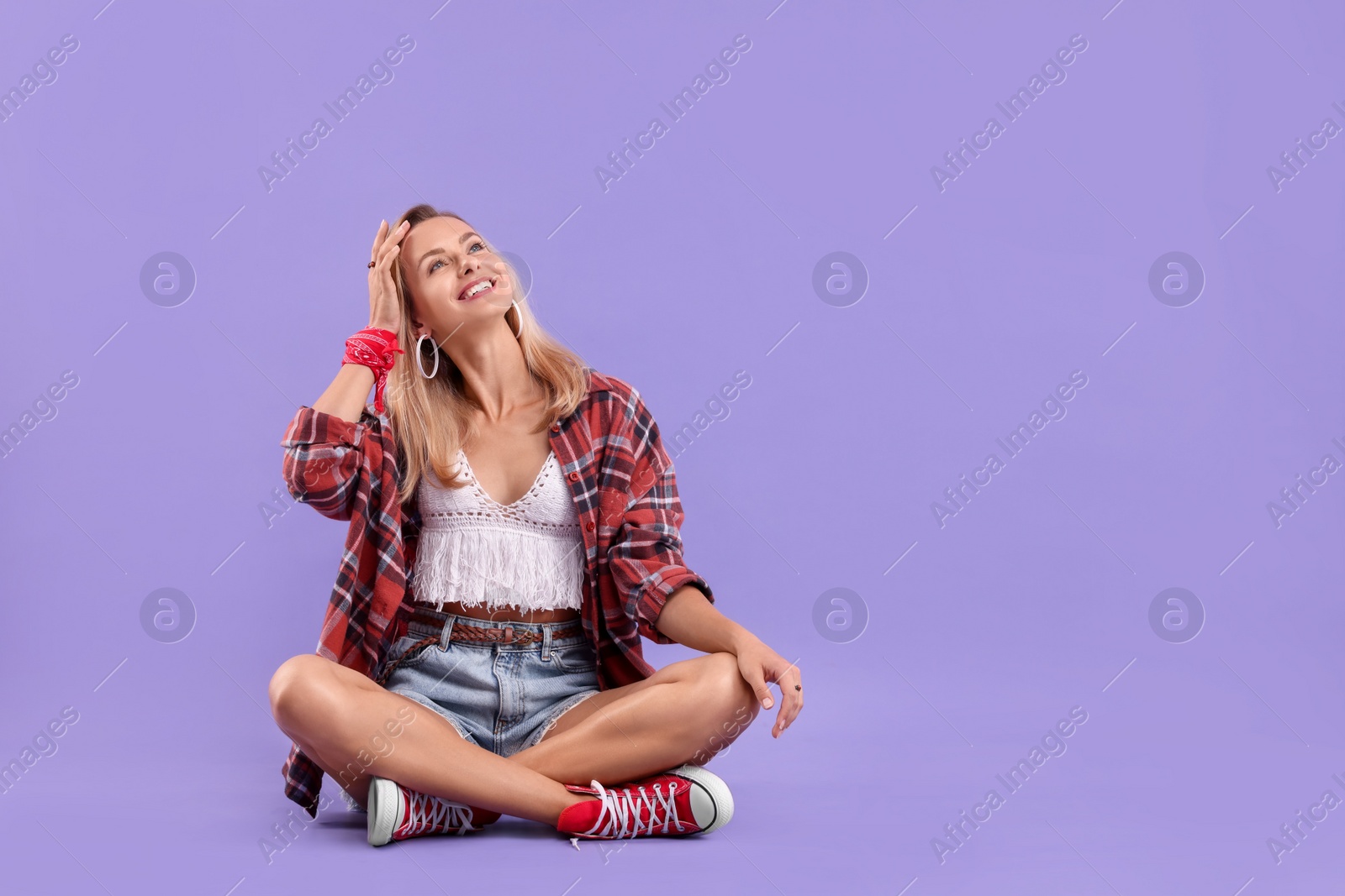 Photo of Happy hippie woman on purple background. Space for text