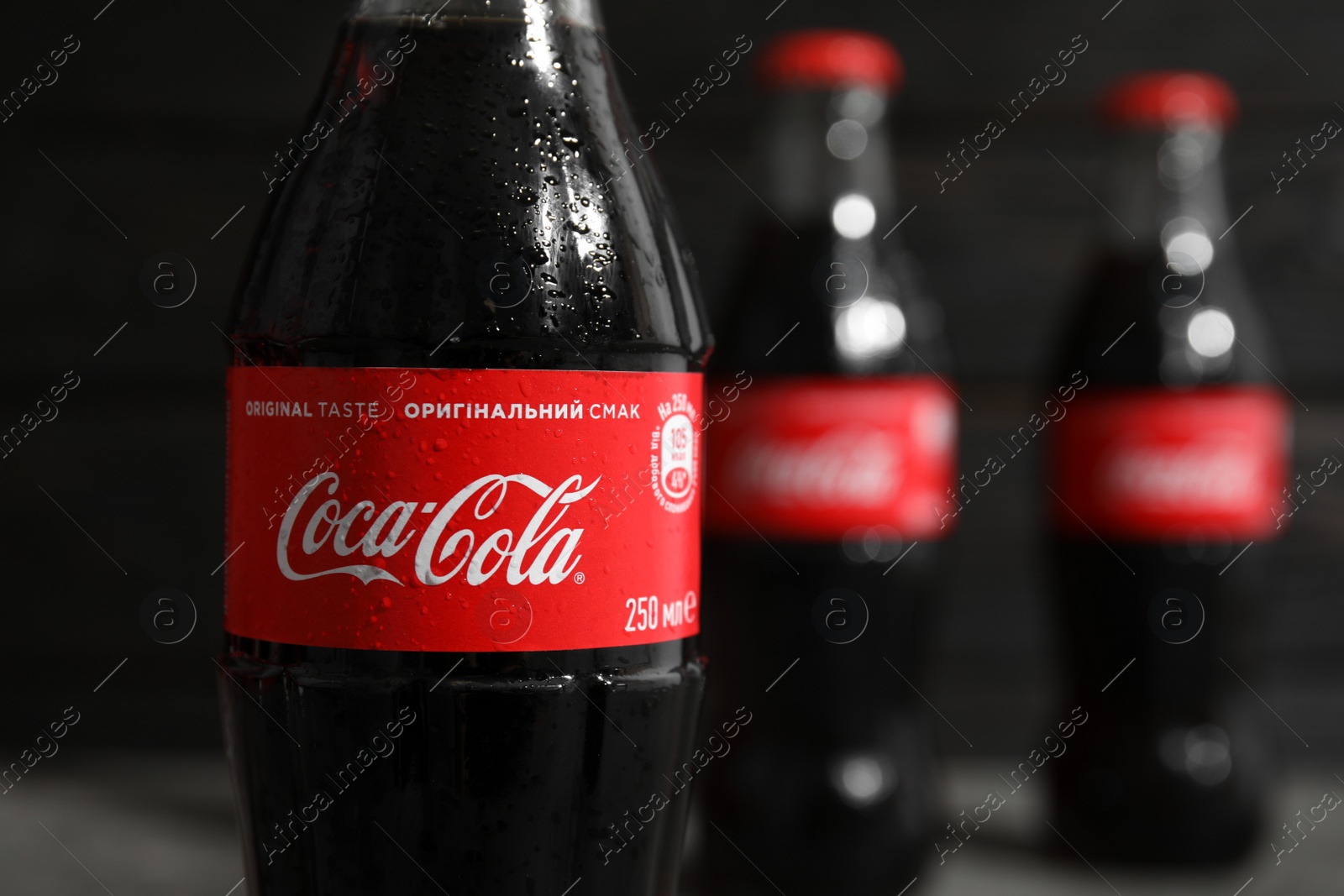 Photo of MYKOLAIV, UKRAINE - NOVEMBER 15, 2018: Bottle of Coca Cola on blurred background, closeup. Space for text