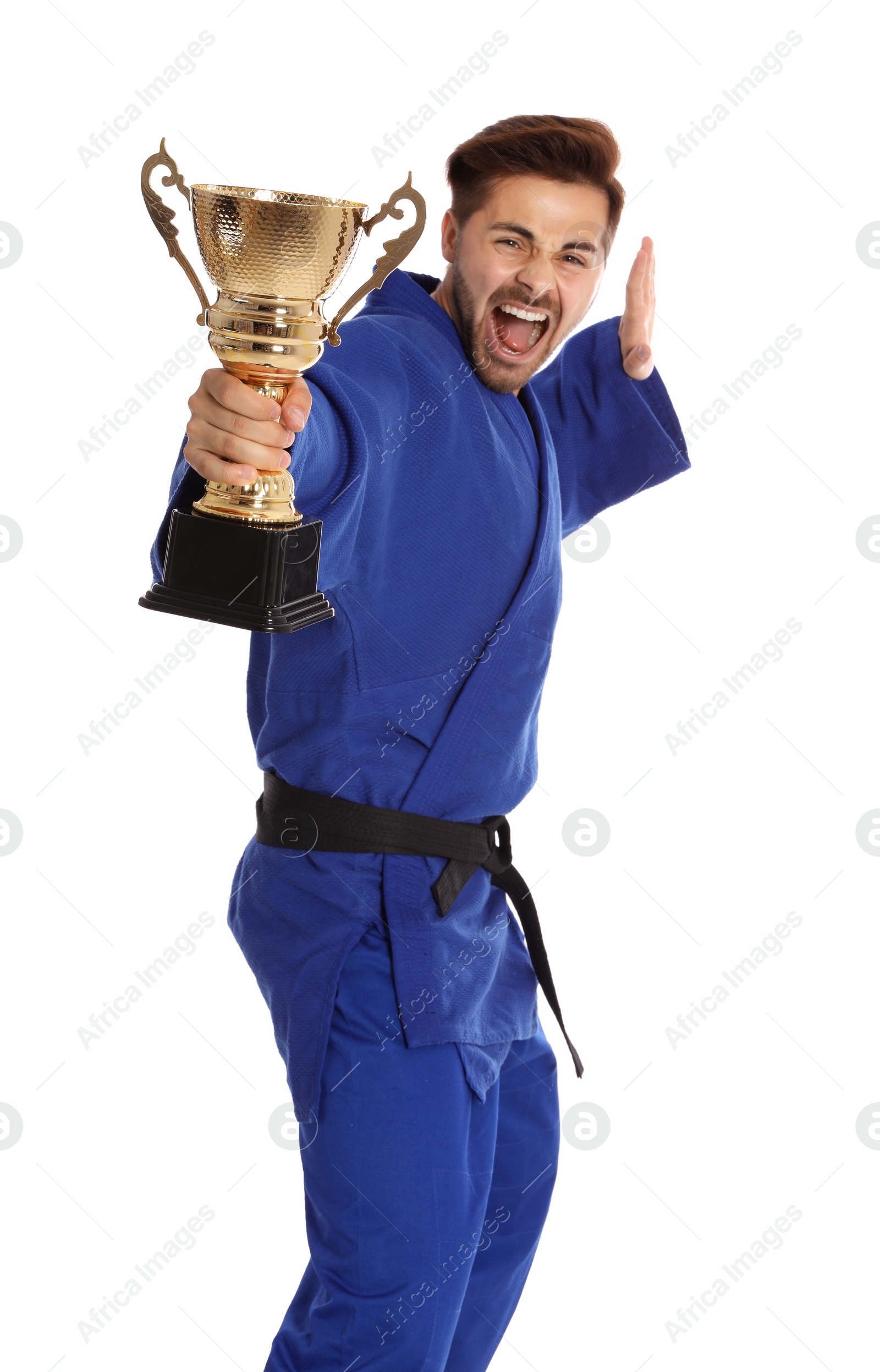 Photo of Portrait of young emotional man in blue kimono with gold trophy cup on white background