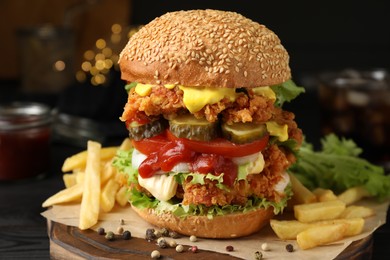Photo of Delicious burger with crispy chicken patty and french fries on table, closeup