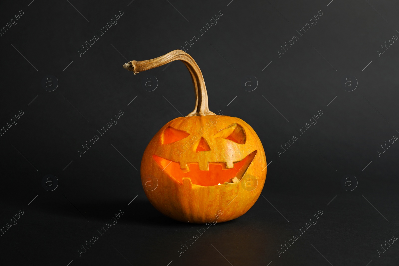 Photo of Halloween pumpkin head jack lantern on dark background