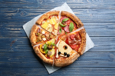 Photo of Slicesdifferent pizzas on blue wooden table, top view