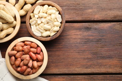 Photo of Fresh peanuts in bowls on wooden table, top view. Space for text