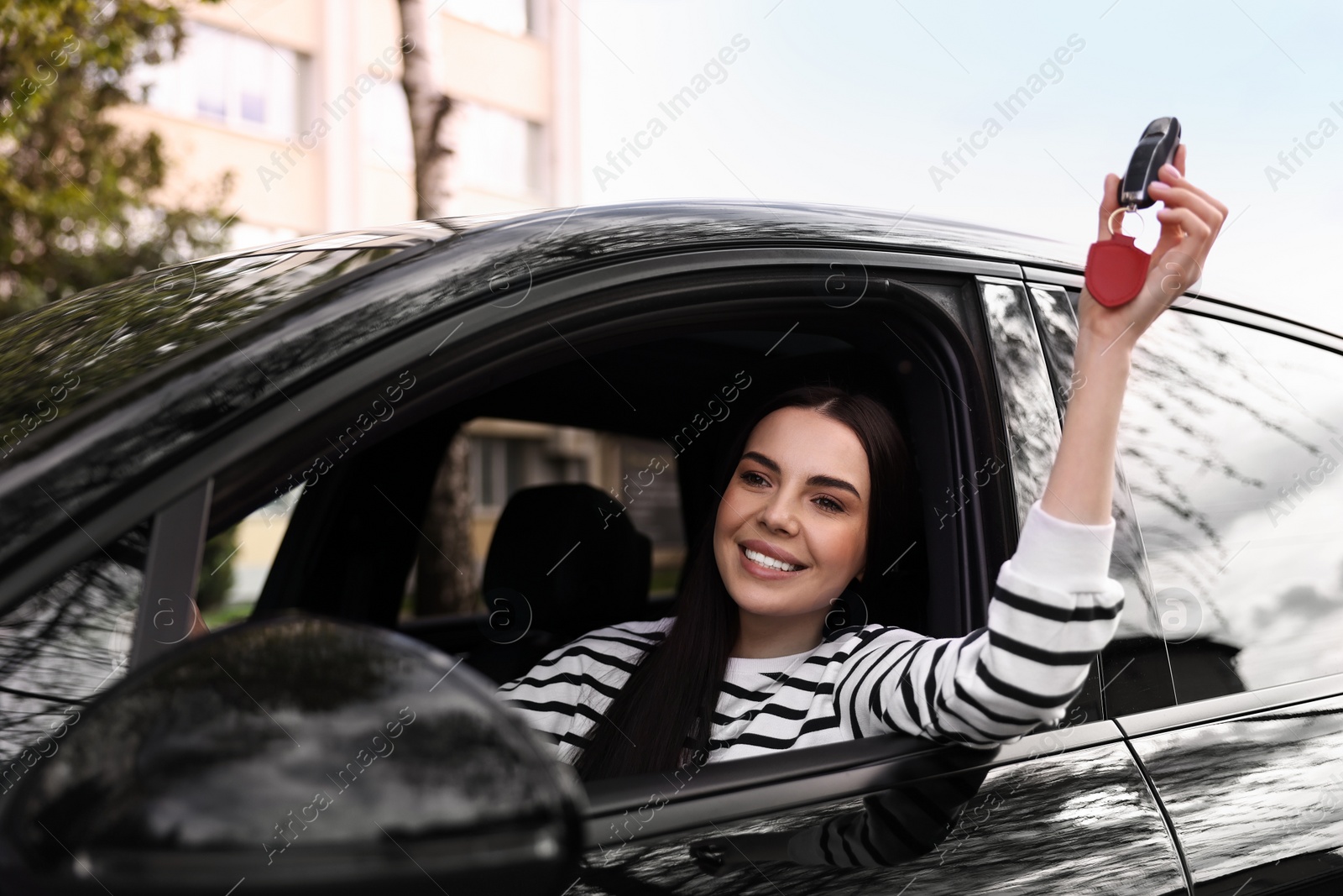 Photo of Woman holding car flip key inside her vehicle