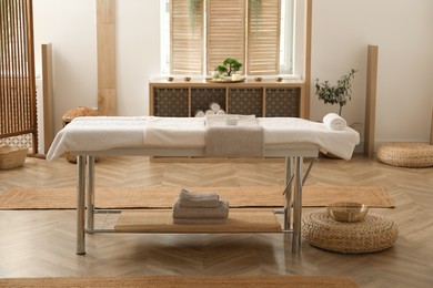 Photo of Stylish massage room interior with spa table in salon