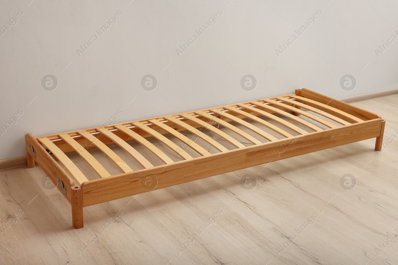 Photo of Wooden bed frame on floor in room