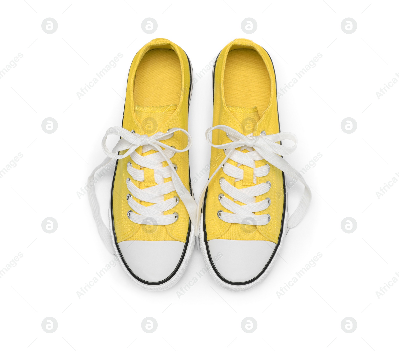 Photo of Pair of yellow classic old school sneakers isolated on white, top view