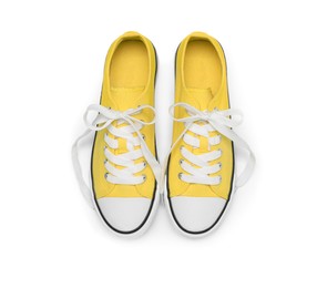 Photo of Pair of yellow classic old school sneakers isolated on white, top view